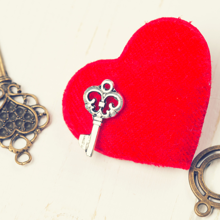 vintage key and red heart on wooden backgroundの写真素材