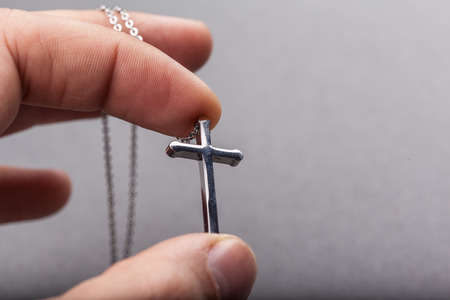 Silver cross in a hand close up imageの写真素材
