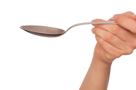 woman holding tablespoon in the hand for feeding a sick personの写真素材