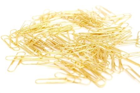 Gleaming golden paperclip isolated on white backgroundの写真素材