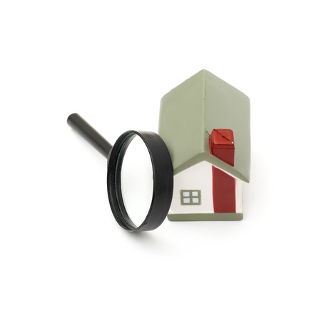 magnifying glass examining model home. Isolated on white.の写真素材