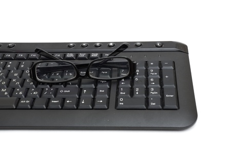 glasses on computer keyboard isolated on white