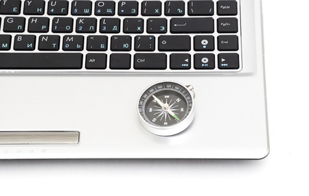 compass on the laptop keyboard isolated on a white backgroundの写真素材