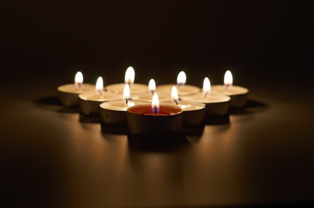 Close up view of the candles cutting through the darkness.の写真素材