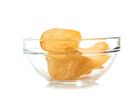 Delicious potato chips in bowl isolated on whiteの写真素材
