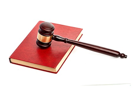 Judge's gavel on red legal bookの写真素材