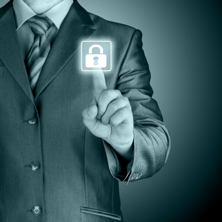 Businessman pushing virtual security button on digital backgroundの写真素材