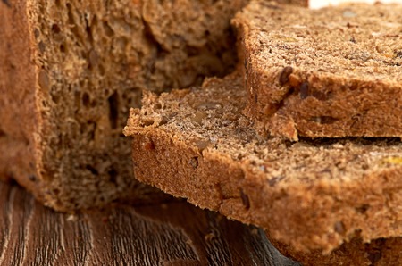 Slices of brown bread on a wooden tableの写真素材