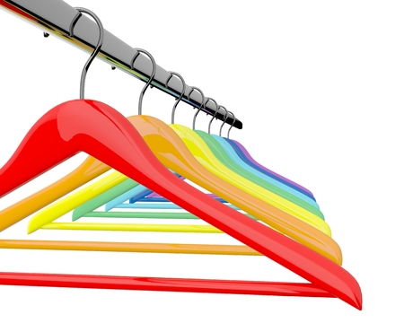 Row of color rainbow coat hangers on metal shiny clothes rail isolated on white backgroundの写真素材