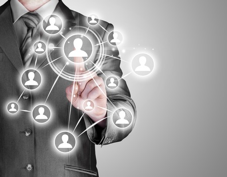 Businessman pressing modern social buttons on a virtual backgroundの写真素材