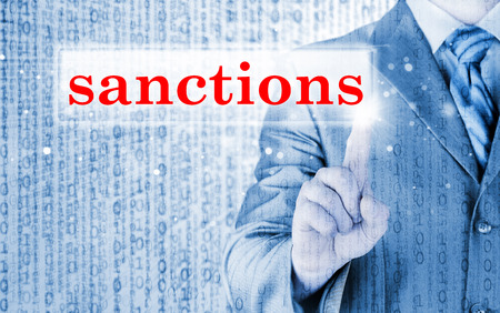 businessman pressing sanctions button on virtual screensの写真素材