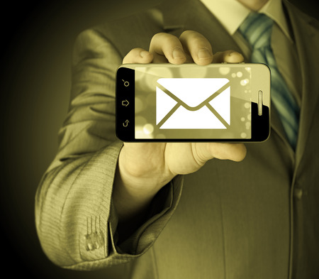 A man holding smartphone with one new message on a screen. Closeup shot.の写真素材