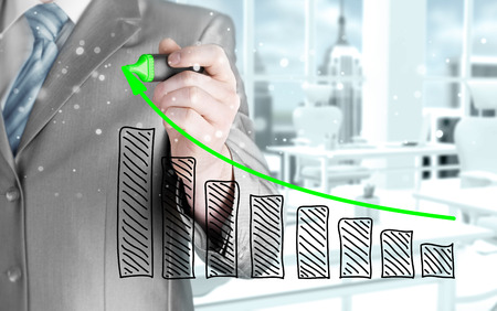 Business man drawing a growing graphの写真素材