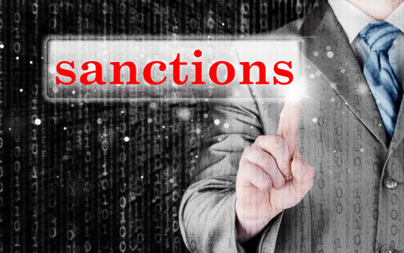 businessman pressing sanctions button on virtual screensの写真素材