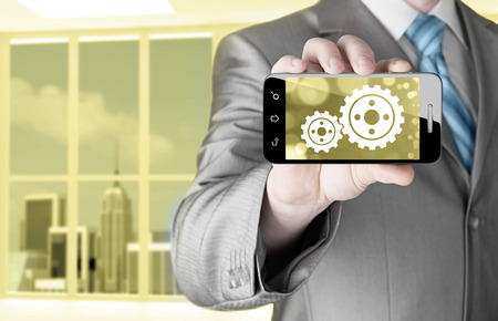 businessman show gear on smartphone to success conceptの写真素材