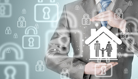 businessman protecting family in home with handsの写真素材