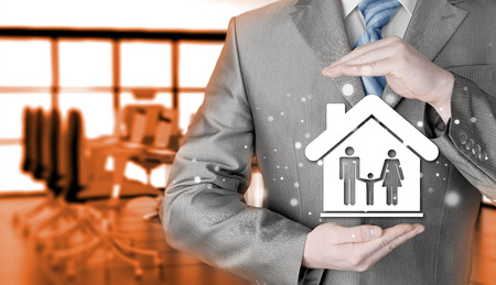 businessman protecting family in home with handsの写真素材