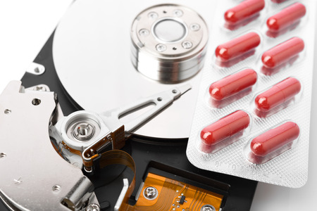 Pills on computer hard drive - concept technology background