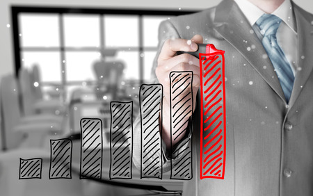 Business man drawing a growing graphの写真素材