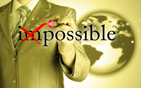 Businessman Hand turning the word Impossible into Possible with red marker