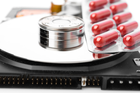 Pills on computer hard drive - concept technology background
