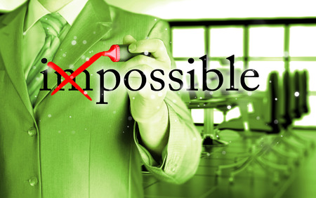 Businessman Hand turning the word Impossible into Possible with red markerの写真素材