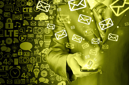 Business man holding smart phone and sending emailsの写真素材