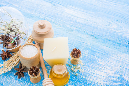 spa treatment -  star anise, honey, salt, arranged with soap bar, pebbles and towels on woodの写真素材