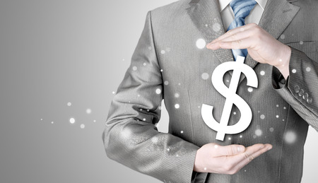 businessman protecting dollar symbolの写真素材