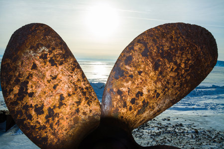 an old rusty screw of a fishing ship on the waterside of the lake Baikal in winterの写真素材