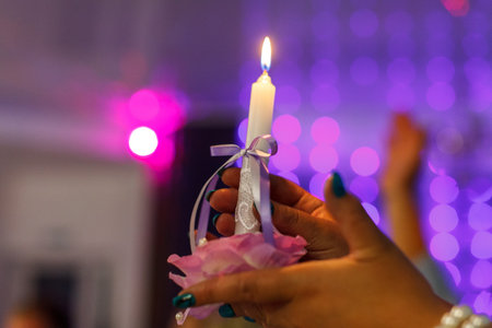 hands with a candle on the wedding ceremony