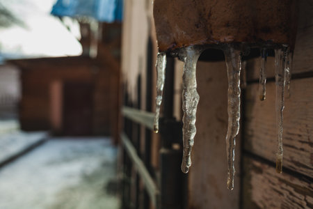 a gully with icicles on an tube in spring