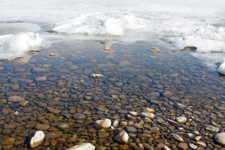 a thawed patch on the Baikal lake shore in springの写真素材