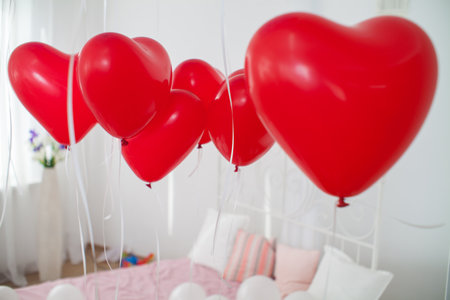 a studio room decorated for a romantic photo session with a lot of red and white balloonsの写真素材