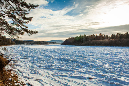 covered with ice a Siberian river behind the branchesの写真素材