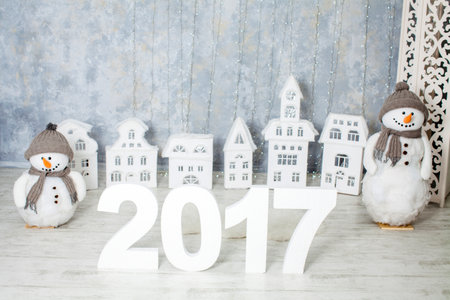 an interior with toy Xmas city, snowmen, numerals 2017 and garland