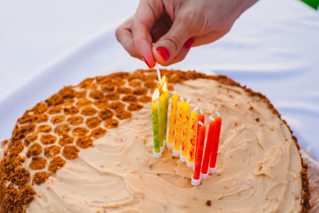This photograph captures a homemade cake with a honeycomb-like design on half of the cake, made using golden brown crumbs to mimic the pattern. The other half of the cake is covered with smooth beige frosting, giving a clean and elegant appearance.の写真素材