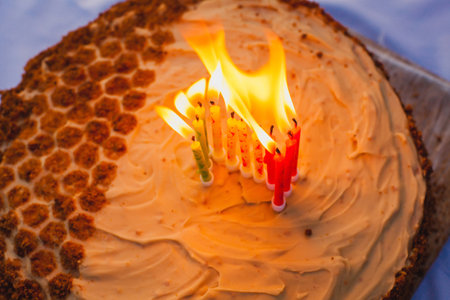 This photograph captures a homemade cake with a honeycomb-like design on half of the cake, made using golden brown crumbs to mimic the pattern. The other half of the cake is covered with smooth beige frosting, giving a clean and elegant appearance.の写真素材