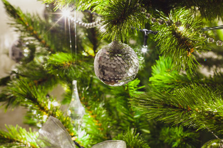 decorations on an artificial green christmas pine tree at homeの写真素材