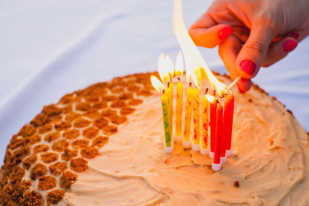 This photograph captures a homemade cake with a honeycomb-like design on half of the cake, made using golden brown crumbs to mimic the pattern. The other half of the cake is covered with smooth beige frosting, giving a clean and elegant appearance.の写真素材