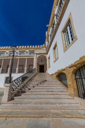 A grand stone staircase ascends towards an arched entrance of a white building with ornate details, framed against a deep blue sky.の写真素材
