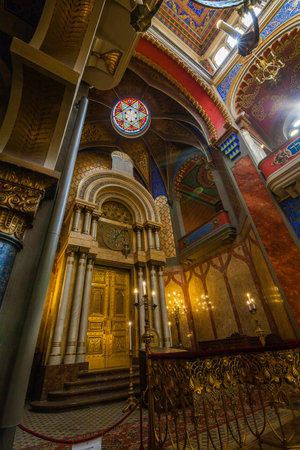 A detailed interior shot of an ornate space featuring a high arched ceiling with a round stained...