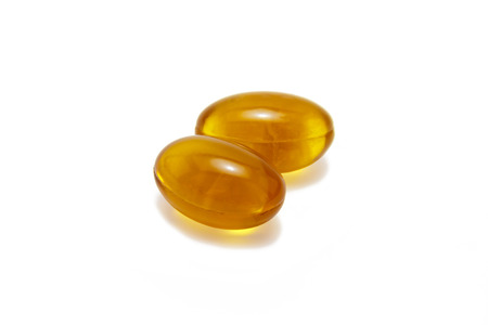 Yellow capsules, isolated on white .
