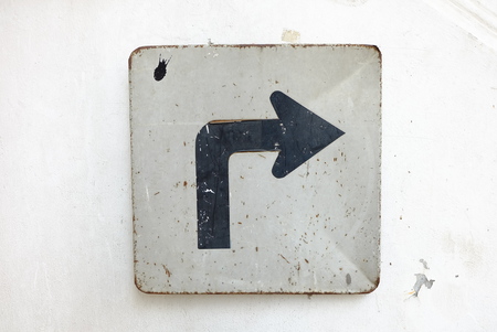 Right Arrow Sign on White Cement Wall Background.の写真素材