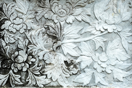 Vintage Thai Sculpture on wall on stone wall.の写真素材