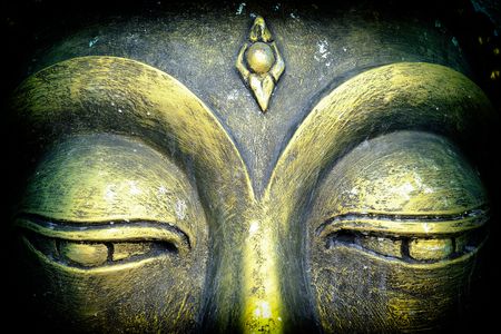 Closed-up Eyes of Buddha Image with Black Len Vintage.の写真素材