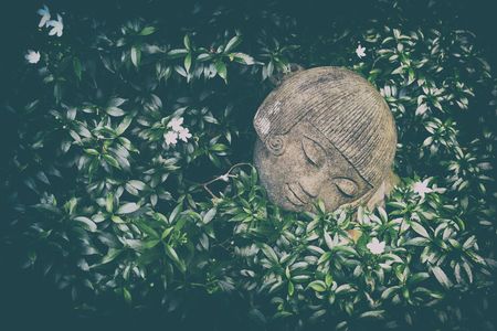 Old Sand Girl Statue in Bush in Vintage Style.の写真素材