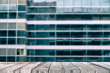Empty Wooden Table with Blurred Building Background for Real Estate Concept, Suitable for Presentation, Web Temple, Backdrop, and Product Display.の写真素材