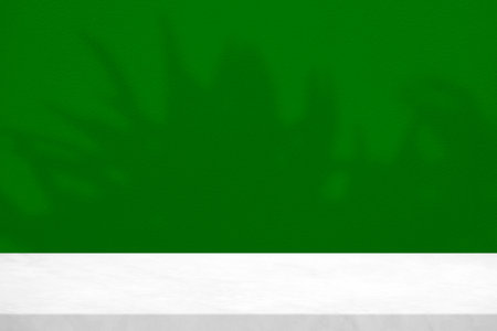 White Marble Table with Leaves Shadow on Green Concrete Wall Texture Background, Suitable for Product Presentation Backdrop, Display, and Mock up.の写真素材
