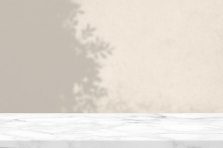 Marble Table with Leaves Shadow on Concrete Wall Texture Background in Set Sail Champagne White Color Tone, Suitable for Product Presentation Backdrop, Display, and Mock up.の写真素材